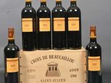 six bottles of red wine in a wooden crate on a table