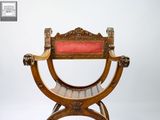 a wooden chair that has a red seat on it