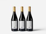 three bottles of wine sitting next to each other on a white surface