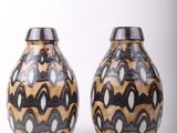 two vases that are sitting side by side on a white surface