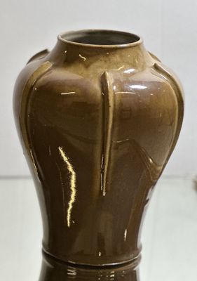 a brown vase that is sitting on a table