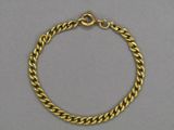 a gold chain bracelet with a clasp on a grey background