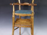 une vieille chaise haute en bois avec un siège bleu sur fond blanc