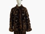 un manteau de fourrure marron posé sur un présentoir à mannequin, surmonté d'un chapeau
