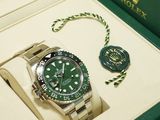 a rolex watch in a box with a guitar pick next to it
