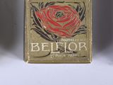 an old match box with a rose on it sitting on a table