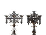 two metal candlesticks on a wooden table on a white background