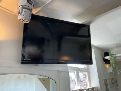 une télévision à écran plat fixée au mur au-dessus d'un miroir