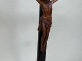 sculpture of a crucifix on a wooden stand with a white background