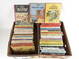 beaucoup de livres dans une boîte en carton posée sur la table