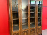 un grand meuble en bois avec des portes en verre dans une pièce