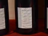three bottles of wine sitting on a red cloth