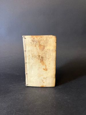an old book sitting on top of a table on a black surface