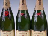 four bottles of champagne are lined up in a row