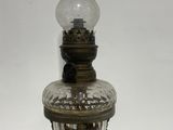 an old fashioned oil lamp with a glass shade on top