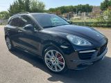 a black porsche cayen is parked in a parking lot