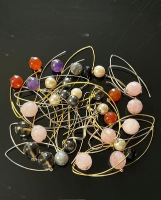 many different colored beads and wire on a black surface