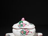 a white and pink porcelain bowl and saucer on a black surface