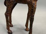 statue de girafe en bois ornée de motifs complexes