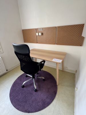 a desk and chair in a room with a purple rug