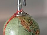 a green globe with a metal handle on top of it