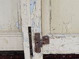 a white door with a rusted handle on a rug