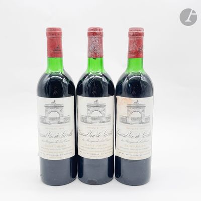 trois bouteilles de vin rouge posées l'une à côté de l'autre sur une surface blanche