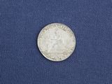 a close up of a silver coin on a blue cloth