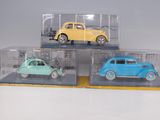 three toy cars in a clear case on a table