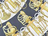 a close up of a scarf with gold and black designs