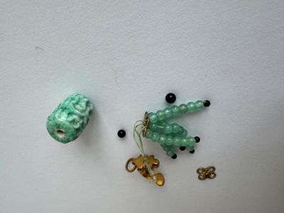 two pieces of jewelry on a white surface next to each other