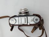 an old camera with a leather strap attached to it