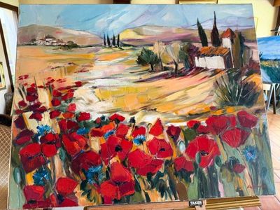 un tableau représentant un champ de fleurs rouges posé sur un chevalet