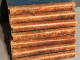 several old books stacked on top of each other on a table