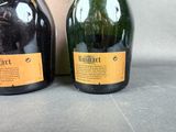 two bottles of wine sitting next to each other on a table