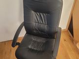a black office chair that is on a wooden floor