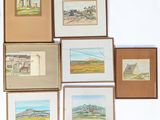 many framed pictures of different landscapes on the wall