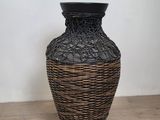 a black and brown vase sitting on a wooden table