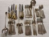 a lot of silver spoons and forks on a table