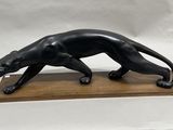sculpture of a black panther on a wooden base on a white background