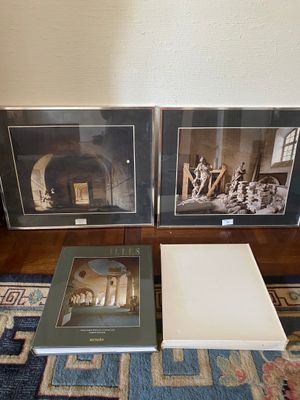 two framed photographs of a fireplace and a book on a blue rug