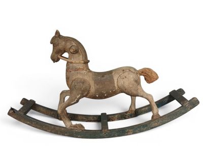 cheval à bascule en bois sur fond blanc, posé sur une surface blanche