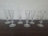 four empty wine glasses lined up on a wooden table