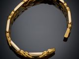 a close up of a gold bracelet on a black background