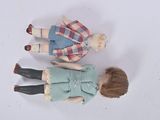 two dolls that are standing next to each other on a table