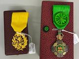 une petite boîte sur laquelle est posée une médaille et une petite boîte sur laquelle est posée une médaille