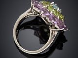 a close up of a silver ring with multi colored stones