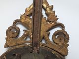 a large metal mirror with a wooden frame on the wall
