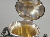 a silver bowl with a lid on a silver stand