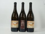 trois bouteilles de vin posées sur une table blanche